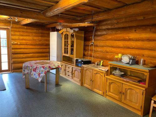 una cocina con paredes de madera y una mesa en una habitación en Väike Kuu peamaja, en Myza Kastre