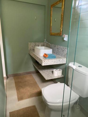 La salle de bains est pourvue de toilettes, d'un lavabo et d'un miroir. dans l'établissement Cantinho na natureza perto das praias, à Niterói