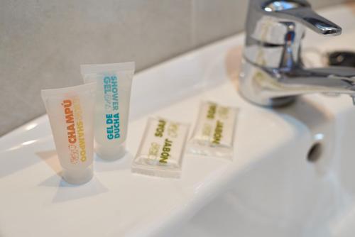 a bathroom sink with two toothbrushes and a toothpaste at Hostal Molgas in A Medorra