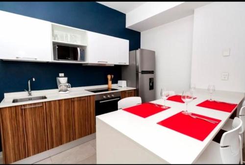 a kitchen with a red and white table in a kitchen at The City Condos Playa del Carmen in Playa del Carmen