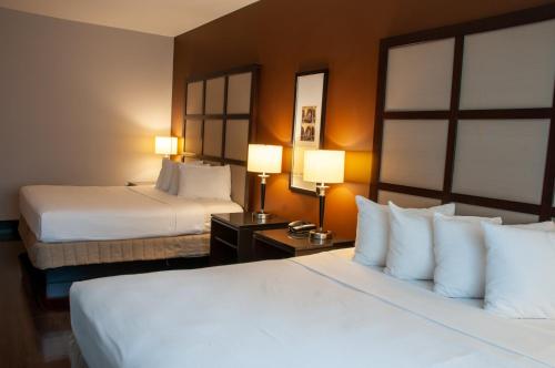 una camera d'albergo con due letti e due lampade di M Montreal Hostel a Montréal