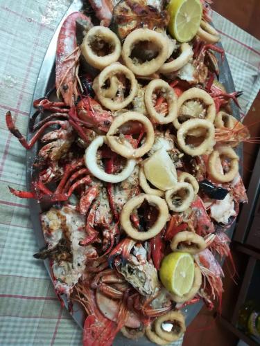 a plate of food with crabs and limes on a table at Hotel Restaurante el Fornon in Novellana