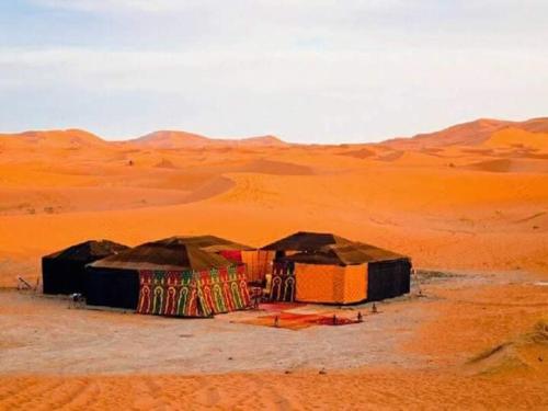 a group of tents in the middle of the desert at Desert life in Mhamid