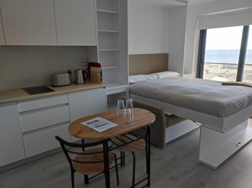 a bedroom with a bed and a table and a bed at The Hub Gibraltar Sacha studio in Gibraltar