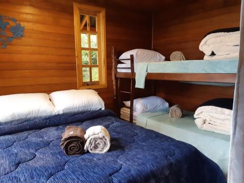 1 dormitorio con 3 literas y toallas. en Chalé Beija-flor - Ninho das Aves, en Campos do Jordão