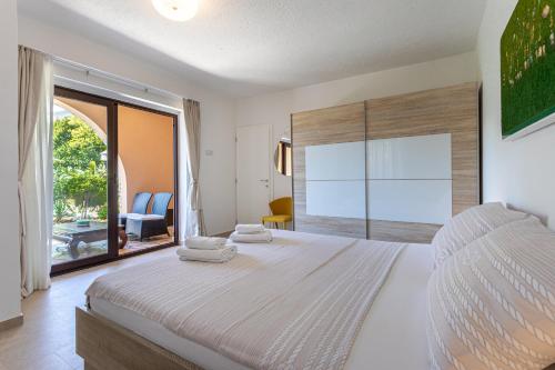 a bedroom with a large bed and a large window at Apartments House Barbara in Kornić