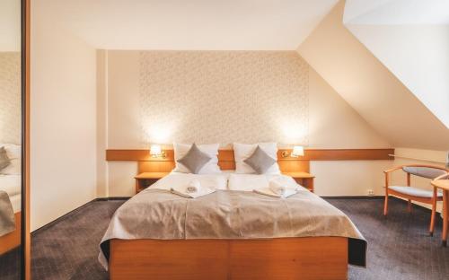 a bedroom with a bed with two towels on it at Thermal Hotel Mosonmagyarovar in Mosonmagyaróvár