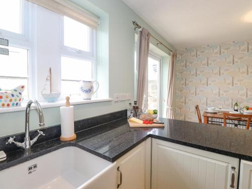 a kitchen with a sink and a counter top at Willow Cottage in Alnmouth