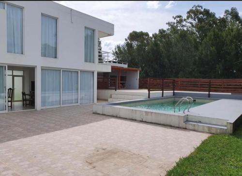 una casa con piscina frente a una casa en casa de categoría en country rumenco en Mar del Plata