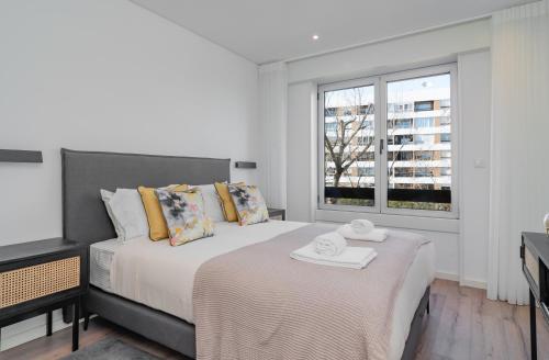 sypialnia z łóżkiem i oknem w obiekcie Coastal Charm by LovelyStay w mieście Oeiras