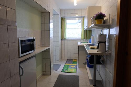 a small kitchen with a sink and a microwave at Pension-Reiche in Struppen