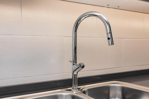 a kitchen sink with a faucet in a kitchen at Coastal Charm by LovelyStay in Oeiras
