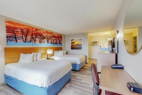 a hotel room with two beds and a table at Days Inn by Wyndham Socorro in Socorro