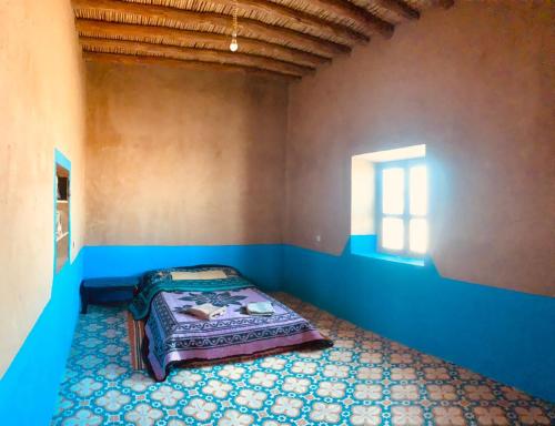 Habitación pequeña con cama en la esquina en Desert Backpackers hostel, en Merzouga