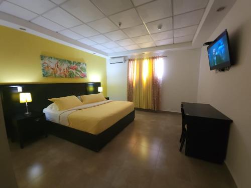 sypialnia z łóżkiem, biurkiem i telewizorem w obiekcie Hotel Coronado Inn w mieście Playa Coronado
