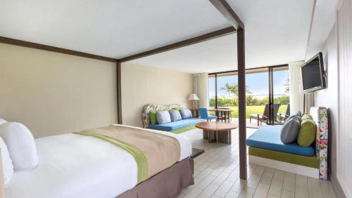 1 dormitorio con 1 cama y balcón con TV en Sandpiper Bay All-Inclusive, Trademark Collection by Wyndham en Port Saint Lucie
