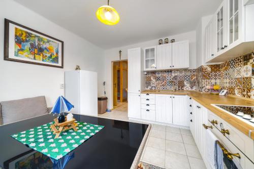 a kitchen with white cabinets and a table with a toy on it at Apartmány Kašper in Levoča