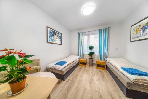 a living room with two beds and a table at Apartmány Kašper in Levoča