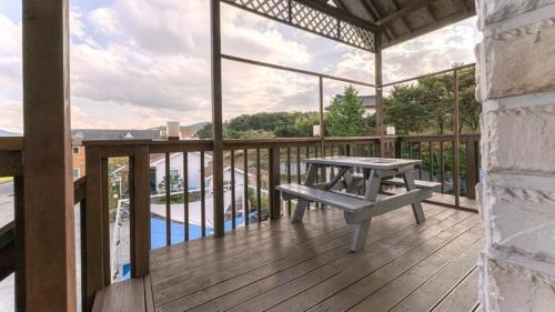 a wooden deck with a picnic table on a balcony at Tinkerbell Pension in Gyeongju