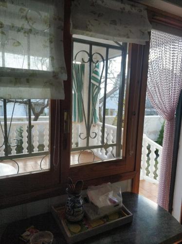 a dining room with two windows and a table at La lechuza blanca in Casavieja