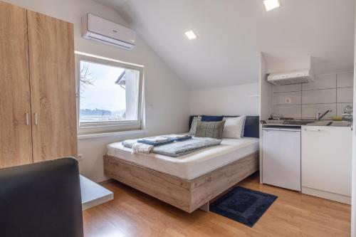 Habitación pequeña con cama y ventana en Apartments Park Vodice - Ljubljana, Krvavec, en Woditz