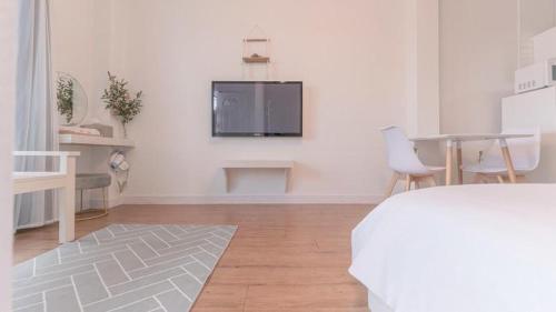a white room with a tv on a wall at Tinkerbell Pension in Gyeongju
