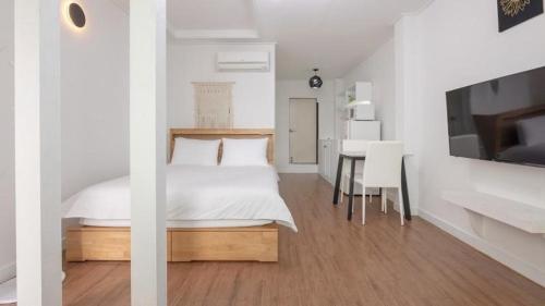 1 dormitorio con 1 cama y 1 mesa con sillas en Tinkerbell Pension en Gyeongju