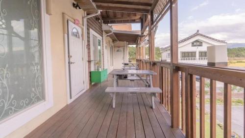 a wooden balcony with benches on a building at Tinkerbell Pension in Gyeongju