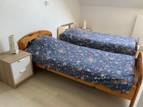 two twin beds in a room with a night stand at Carpe Diem in Jumet