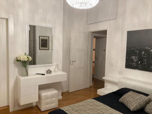 a bedroom with a bed and a sink and a mirror at Thesan Lodge, chic & modern design apartment in Grosseto