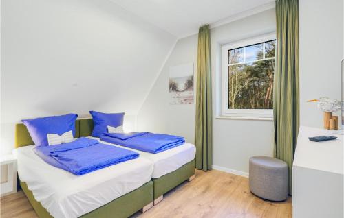 een slaapkamer met een bed met blauwe kussens en een raam bij Reetdachhaus 27 Auf Usedom in Kutzow