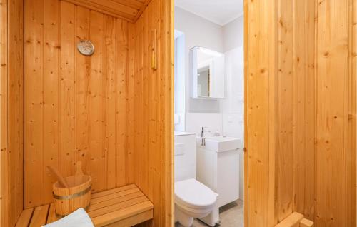 een houten badkamer met een toilet en een wastafel bij Reetdachhaus 27 Auf Usedom in Kutzow
