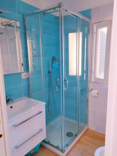 Un baño con ducha de cristal y lavabo. en Cetara Sunny House, en Cetara