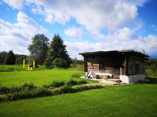 a small wooden building in a field with a playground at Kõrtsimaja in Myza Kastre