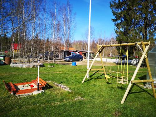 a group of swings in a grassy yard at Kõrtsimaja in Myza Kastre