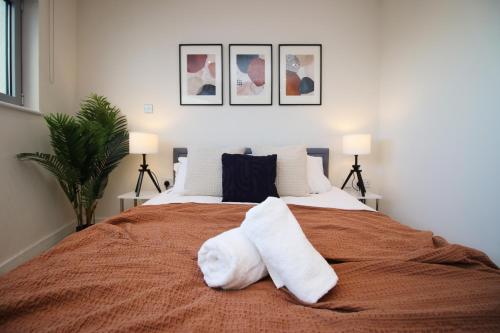 a bedroom with a bed with two white towels on it at The Skyline - LONG STAY OFFER - Luxury Flat w/Designated Parking in Cardiff