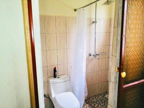 y baño con aseo y ducha. en Home from home en Mbale
