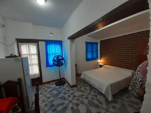 a bedroom with a bed and a brick wall at Alojamiento Los Amigos in Vaqueros