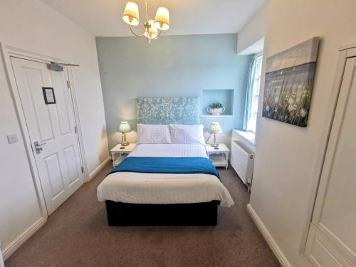 1 dormitorio con 1 cama con colcha azul y blanca en The Elleray, en Windermere