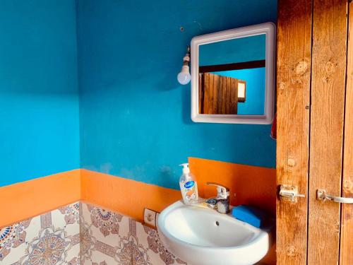 y baño con lavabo y espejo. en Desert Backpackers hostel, en Merzouga