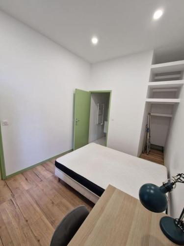 a room with a bed and a table and chairs at Magnifique Appartement de Type 2 in Saint-Étienne