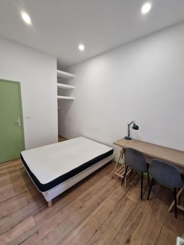 Habitación con cama, mesa y sillas. en Magnifique Appartement de Type 2, en Saint-Étienne