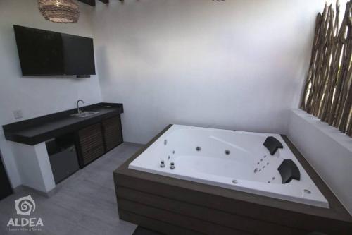 ein Badezimmer mit einer Badewanne und einem Waschbecken in der Unterkunft SUITE CON JACUZZI Y TERRAZA PRIVADOS EN PIRAMIDES in San Martín de las Pirámides