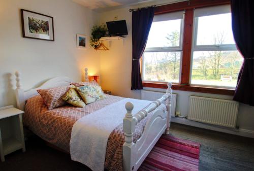 a bedroom with a bed and a large window at The Red Red Robin Cottage in Portree