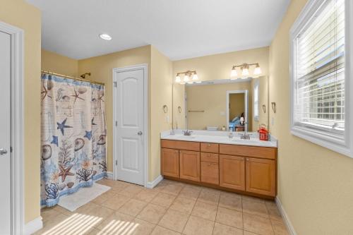 Southern Shores的住宿－The Sandlot，浴室配有盥洗盆和带镜子的淋浴
