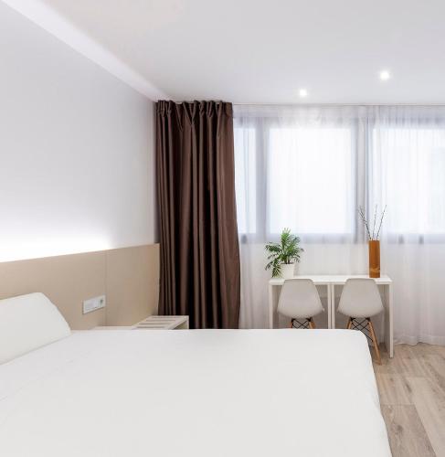 a bedroom with a bed and a desk and a window at Hotel BESTPRICE Alcalá in Madrid