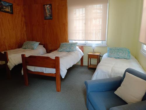 Habitación con 2 camas, silla y sofá en Hotel Paseo Valle, en Viña del Mar