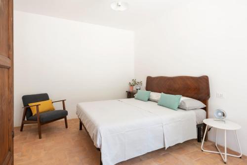 a bedroom with a white bed and a chair at Piano del Mulino in Orvieto