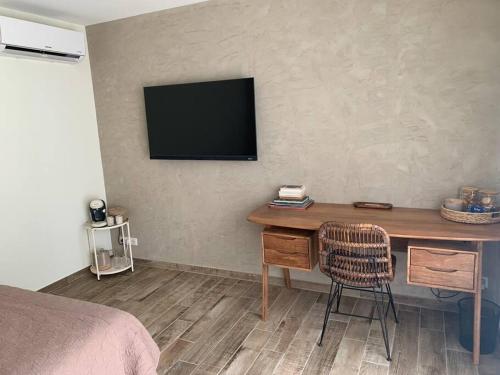 a bedroom with a desk with a television on the wall at Villa familiale 9 pers Cabries entre Aix et Marseille 5 min gare Aix TGV 15 min aéroport MP in Cabriès