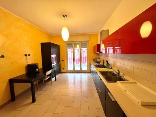 een grote keuken met rode en gele muren bij Bergamoinhouse in Bergamo